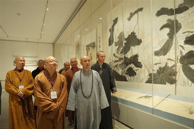 法華寺住持萬德法師(前右)以藝術弘揚佛法,陪同中華人間佛教聯合總會輪值主席心保和尚(前左)等一行參觀其翰墨丹青作品。